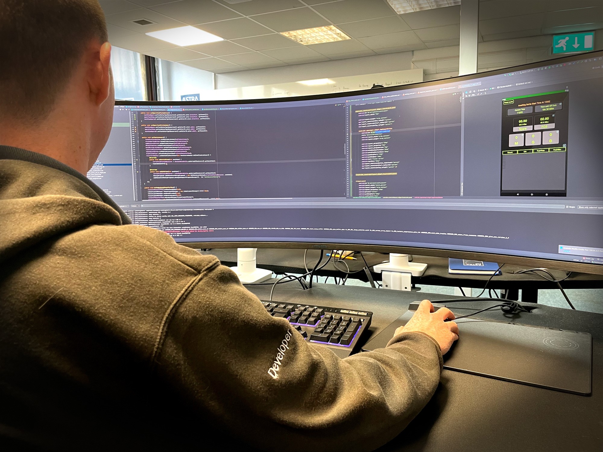 Developer sits at desk working on computer.